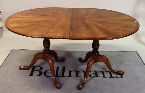 A modern mahogany and yew wood banded 'D' end extending dining table on baluster column and three downswept supports with one extra leaf