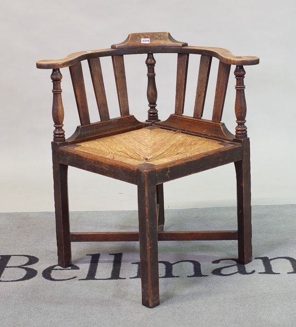 A 19th century oak corner chair with rush seat on block supports