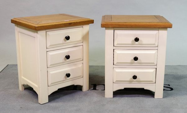 A pair of modern white painted bedside chests with oak tops over three drawers