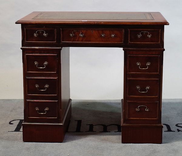 A modern stained beech kneehole pedestal desk with an inset leather top