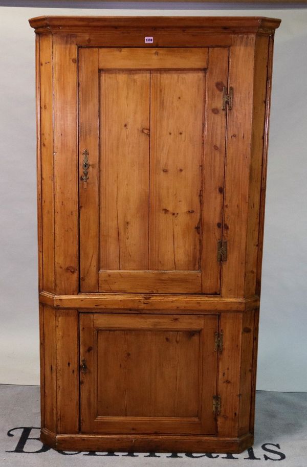 An early 20th century pine floorstanding corner cupboard