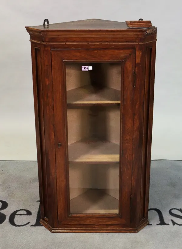 A small walnut hanging corner cabinet with glazed door