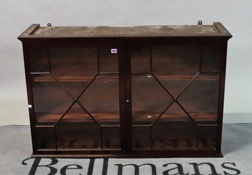 An early 19th century mahogany astragal two door hanging display cabinet