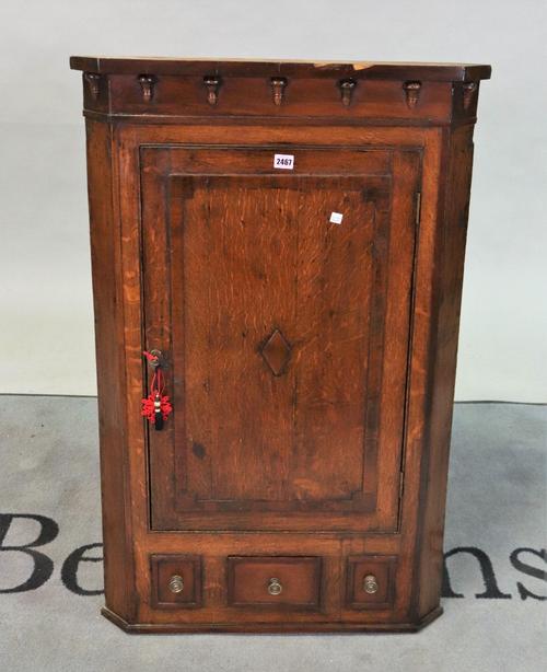 A George III mahogany banded oak hanging corner cupboard
