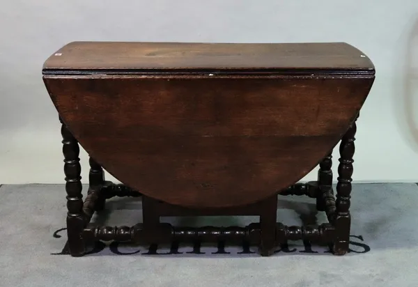 A 17th century oak oval drop flap dining table