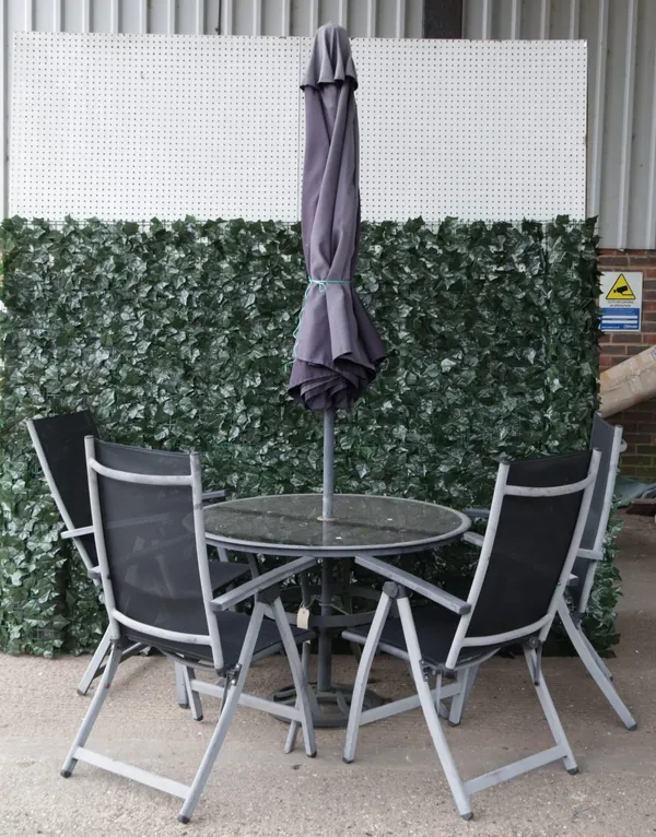 A modern grey painted metal and glass circular garden table with associated umbrella,