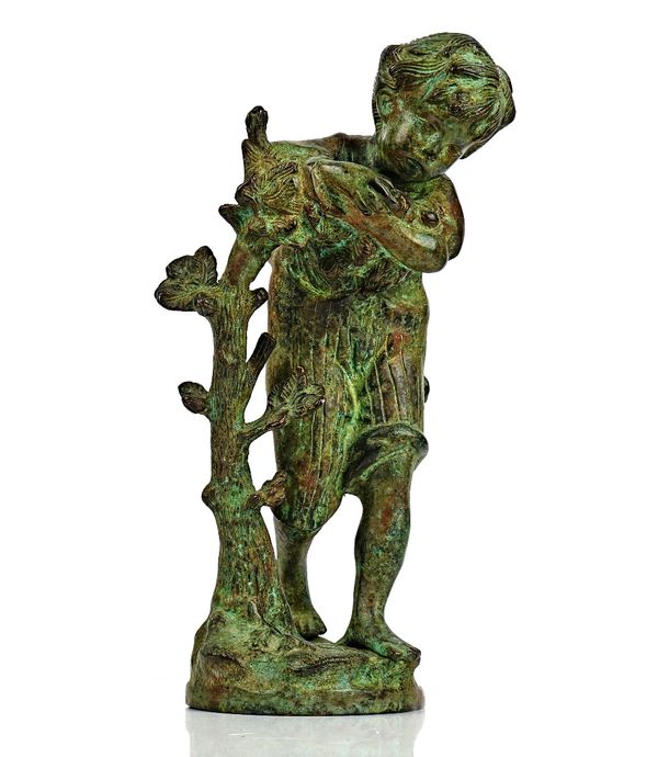 A patinated bronze sculpture of a boy