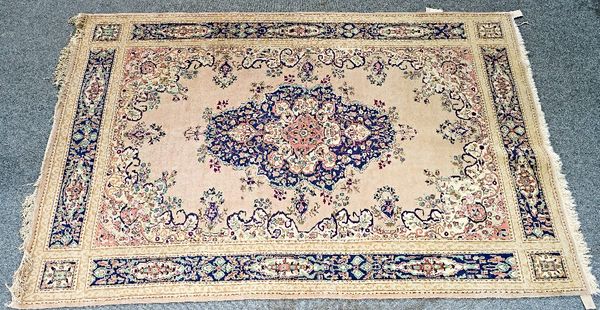 A Konya carpet, Turkish, the pale pink field with a dark indigo medallion, and outer surround, a complementary border, 314cm x 206cm