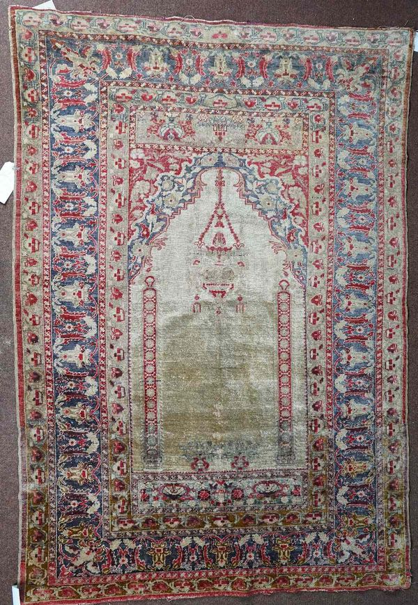 An antique silk Turkish prayer rug, the light brown mehrab with a pair of columns rising to a hanging lantern; floral arch above; an indigo palmette and leaf border, 180 x 124cm.