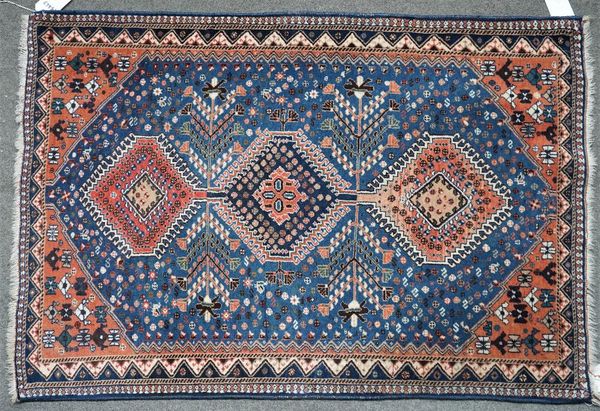 A South Persian rug, the indigo field with an indigo and two madder medallions, minor motifs, madder spandrels, a zig zag border, 154cm x 105cm.