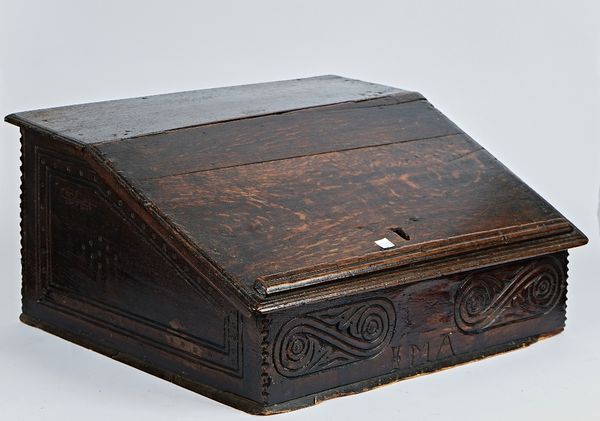 A 17th century oak slope front bible box with carved frieze, 55cm wide; 27cm high