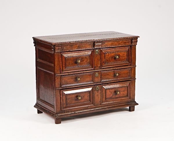 A Charles II oak chest with three long raised geometric drawers, on stile feet, 98c, wide x 79cm high.