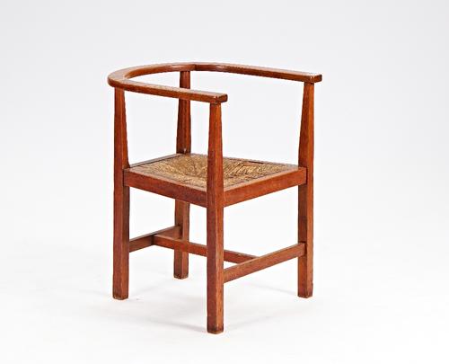 An oak Arts and Crafts tub back open armchair on block supports, 61cm wide x 77cm high.