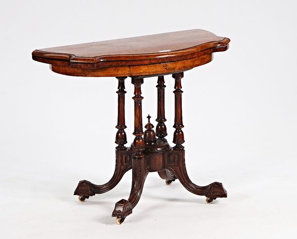 A Victorian figured walnut card table of serpentine outline on turned columns and four down swept supports, 90cm wide x 73cm high.