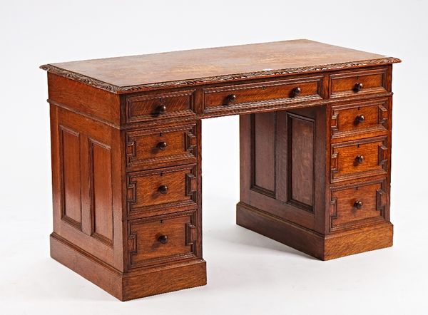 An oak pedestal desk with nine drawers about the knee, 123cm wide x 63cm deep.