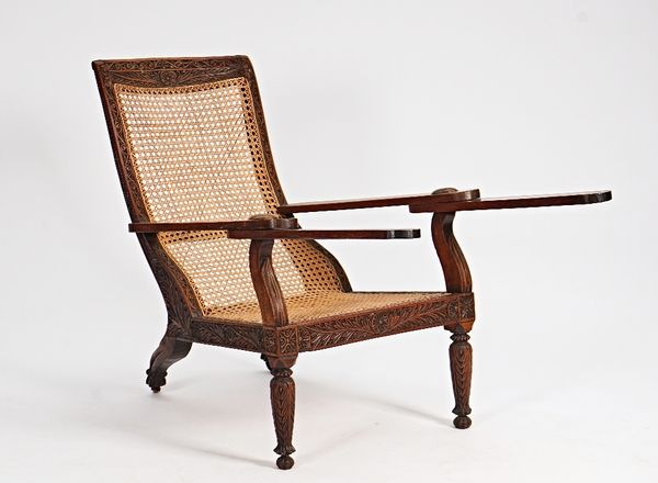 A 19th century carved hardwood cane plantation chair, 70cm wide x 90cm high.