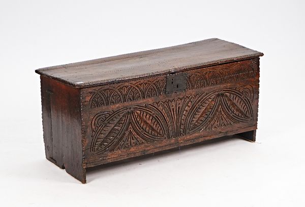 A 17th century oak five plank coffer, with carved front panel, on slab end supports, 120cm wide x 54cm high.