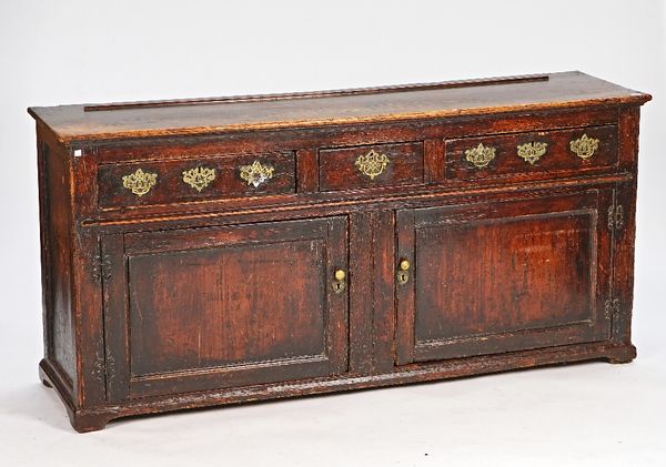 A George III pine dresser base, with three drawers over a pair of cupboards, 184cm wide x 88cm high.