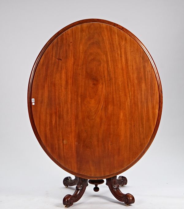 A 19th century mahogany oval snap top centre table on four carved downswept supports, 140cm wide x 75cm high.