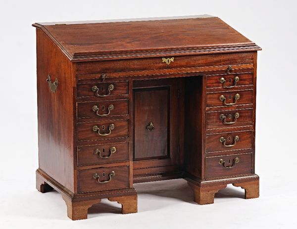 A mid-18th century Irish mahogany estate desk with lift slope top over brushing slide and ten short drawers about the knee cupboard, 110cm wide x...