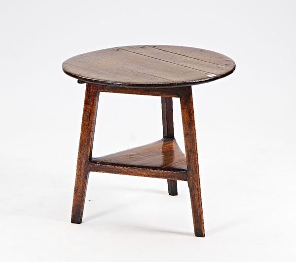 A George III oak cricket table, with triangular platform undertier, 70cm diameter x 65cm high.