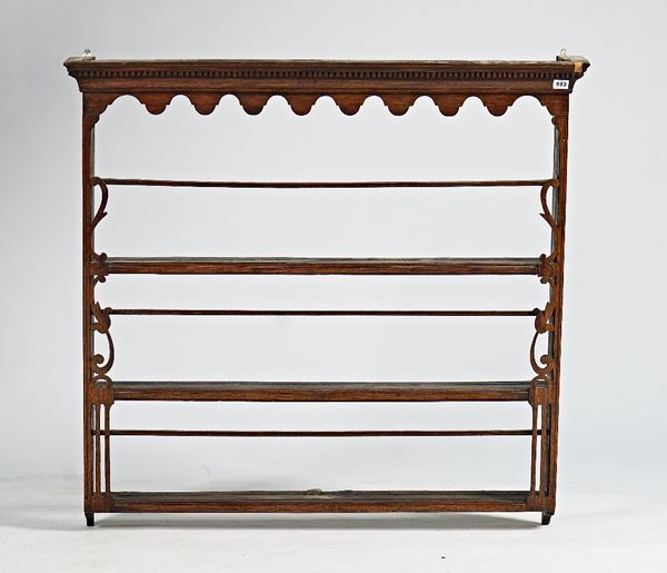 An 18th century oak hanging open wall shelf, with pierced and fret carved decoration, 107cm wide x 101cm high.
