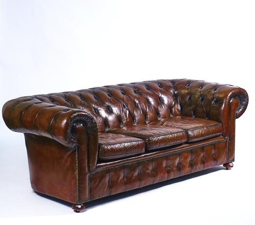 A 20TH CENTURY STUDDED BROWN LEATHER UPHOLSTERED CHESTERFIELD SOFA