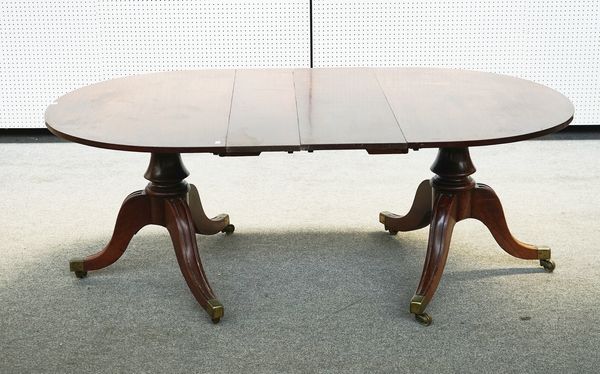 A GEORGE III MAHOGANY TWIN PEDESTAL EXTENDING DINING TABLE