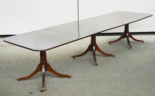A GEORGE III MAHOGANY TRIPLE PILLAR DINING TABLE