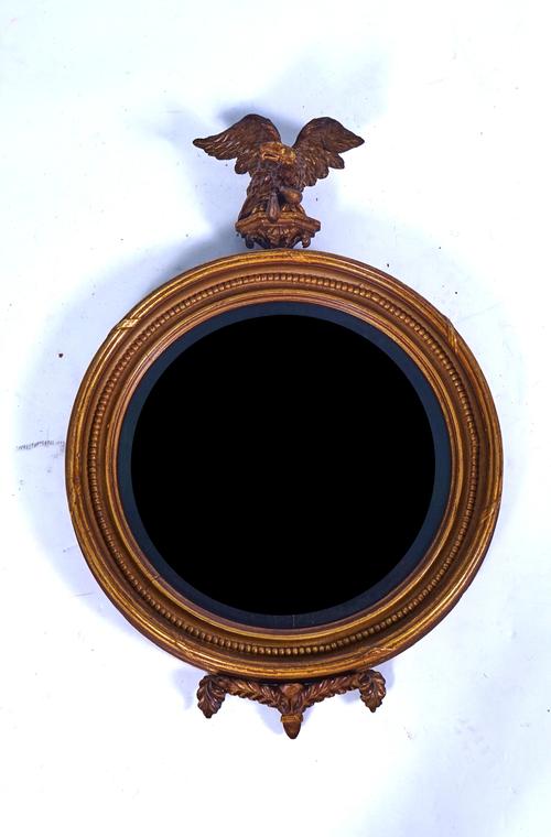 A REGENCY GILT FRAMED CONVEX MIRROR WITH EAGLE FINIAL
