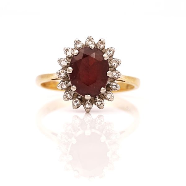 AN 18CT GOLD RHODOLITE GARNET AND DIAMOND SET OVAL CLUSTER RING
