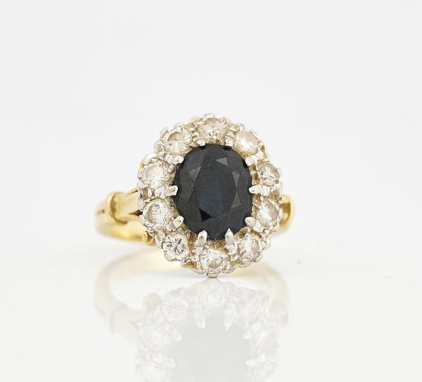 A GOLD, SAPPHIRE AND DIAMOND OVAL CLUSTER RING