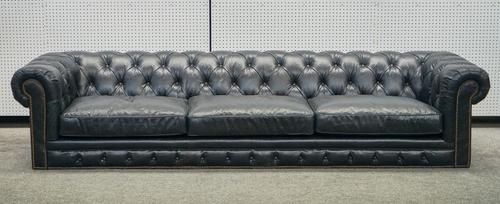 A LARGE STUDDED BLACK LEATHER UPHOLSTERED CHESTERFIELD SOFA