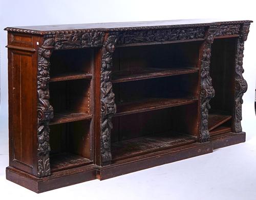 A VICTORIAN CARVED OAK BREAKFRONT FLOOR STANDING OPEN BOOKCASE