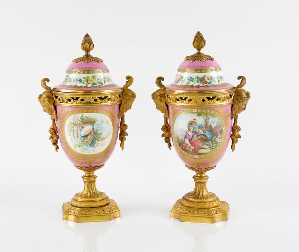 A PAIR OF ORMOLU MOUNTED SEVERES-STYLE PINK GROUND PORCELAIN URNS AND COVERS (2)