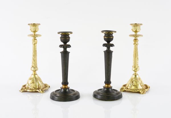 A PAIR OF REGENCY PARCEL-GILT PATINATED CANDLESTICKS; TOGETHER WITH ANOTHER PAIR  (4)