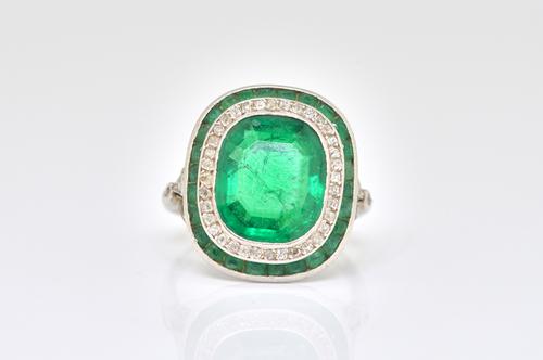 AN EMERALD AND DIAMOND OVAL RING