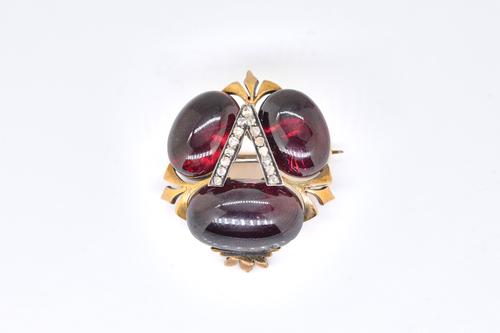 A CARBUNCLE GARNET AND DIAMOND INITIAL 'A' BROOCH