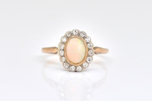 A GOLD OPAL AND DIAMOND OVAL CLUSTER RING
