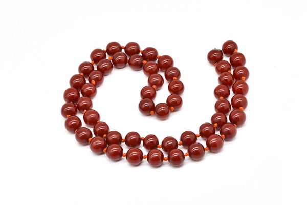 A SINGLE ROW NECKLACE OF CHERRY COLOURED RECONSTITUTED AMBER BEADS