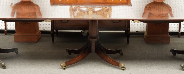 A GEORGE III STYLE MAHOGANY TRIPLE PILLAR EXTENDING DINING TABLE