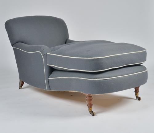 A GREY UPHOLSTERED CHAISE LONGUE WITH ARMS