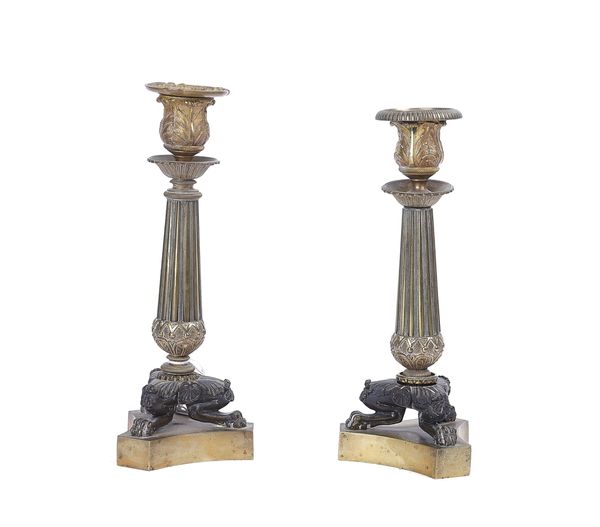 A PAIR OF EMPIRE STYLE GILT AND PATINATED BRONZE CANDLESTICKS