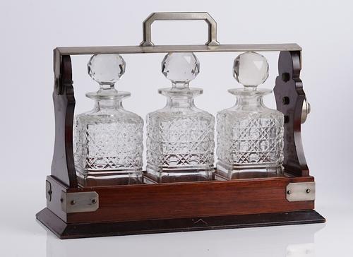 AN EDWARDIAN MAHOGANY THREE BOTTLE TANTALUS