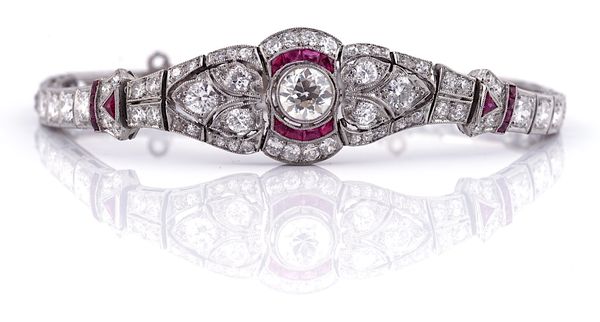 AN ART DECO STYLE DIAMOND AND RUBY SET THITE PRECIOUS METAL BRACELET