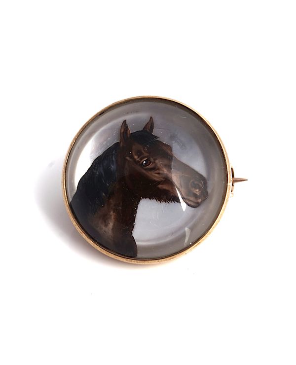 A GOLD MOUNTED, REVERSE PAINTED INTAGLIO CRYSTAL BROOCH