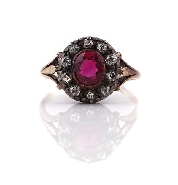 A DIAMOND AND SYNTHETIC RUBY SET OVAL CLUSTER RING