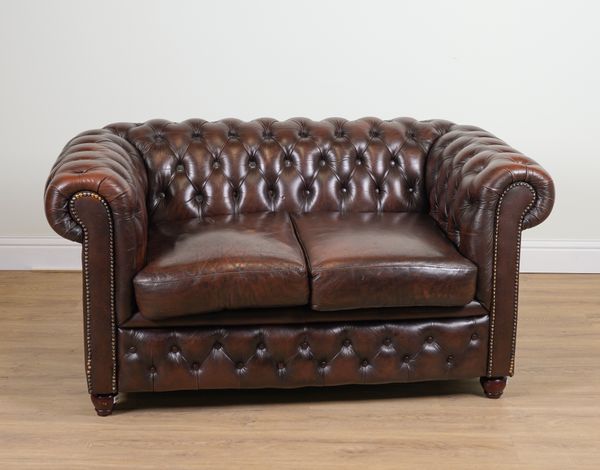 A BRASS STUDDED BROWN LEATHER UPHOLSTERED TWO SEAT CHESTERFIELD SOFA