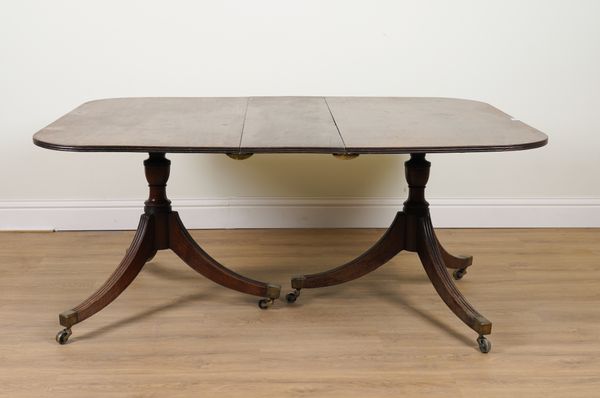 A GEORGE III MAHOGANY TWIN PILLAR EXTENDING DINING TABLE