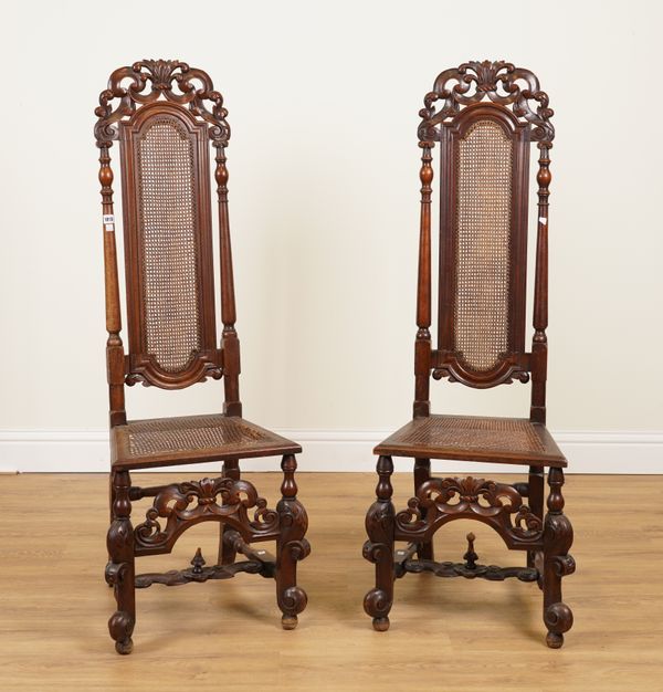 A PAIR OF WILLIAM AND MARY STYLE CARVED WALNUT AND CANE HIGH BACK SIDE CHAIRS (2)